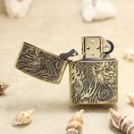Open Phoenix brass Zippo Armor lighter showing engraved artwork