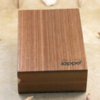 Wooden Zippo lighter case on a light surface, close-up of the wood grain and logo