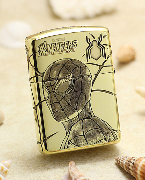 Gold metal lighter featuring Spider-Man drawing and Avengers: Infinity War logo on a sandy beach background.