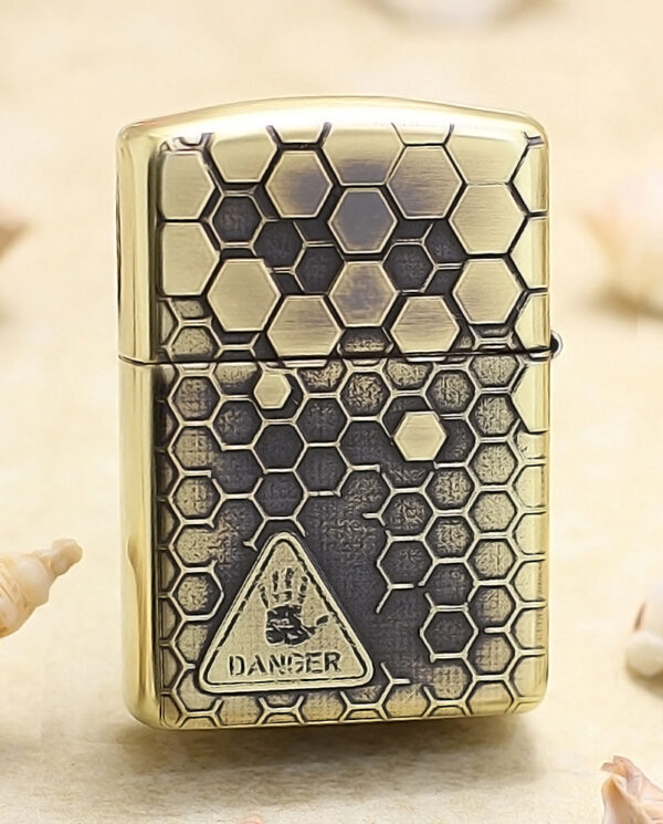 KZ240-01 Brass Zippo-style lighter with a honeycomb hexagon pattern and a danger symbol on the front.