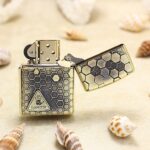 Open brass Zippo Armor lighter with black honeycomb and danger label