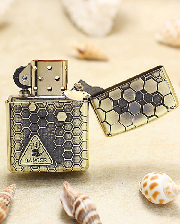 KZ240-03 Gold Zippo-style lighter with a black honeycomb hexagon pattern and a triangular 'DANGER' label on the front, open lid.