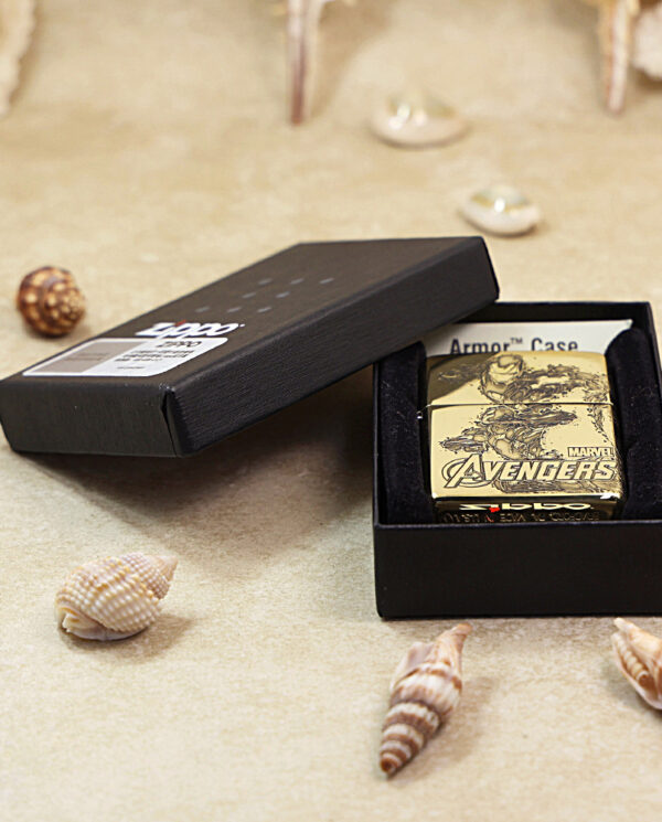 KZ241-06 Gold Avengers Armor Case in an open black box on a sandy beach with seashells around it.