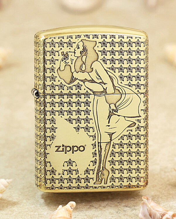 Gold-tone Zippo lighter with a stylized woman smoking motif set against a star-patterned background