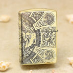 Gold Zippo lighter with ornate medieval engraving, including a hooded figure and intricate knotwork.
