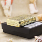 Gold Zippo lighter with engraved designs resting on a black display box