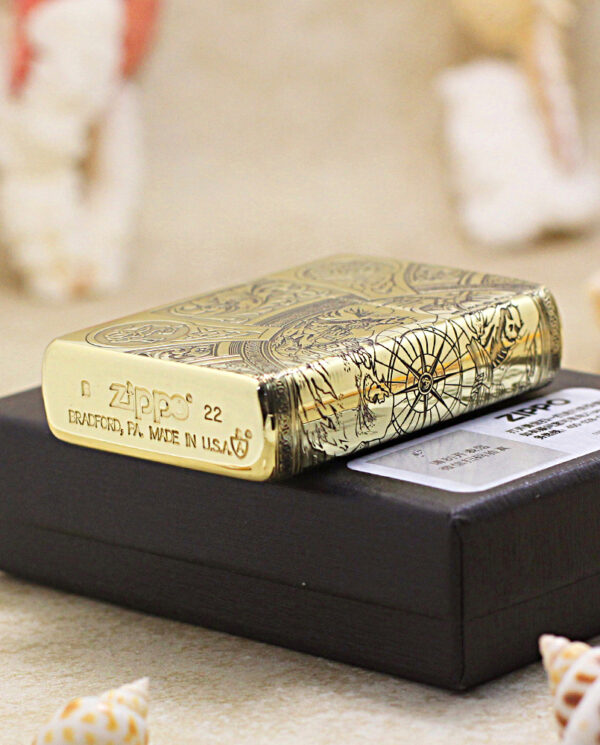 KZ245-05 Gold Zippo lighter with engraved designs resting on a black display box
