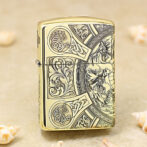 Gold Zippo lighter with intricate Celtic knotwork and floral engravings on its surface.