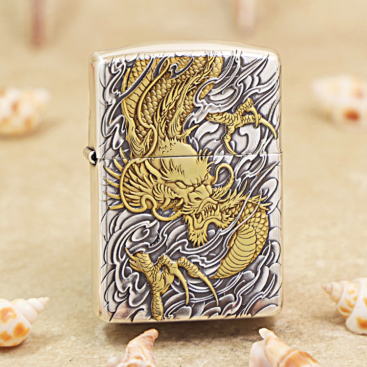 Metal lighter with a gold dragon engraving on a silver, swirling background.