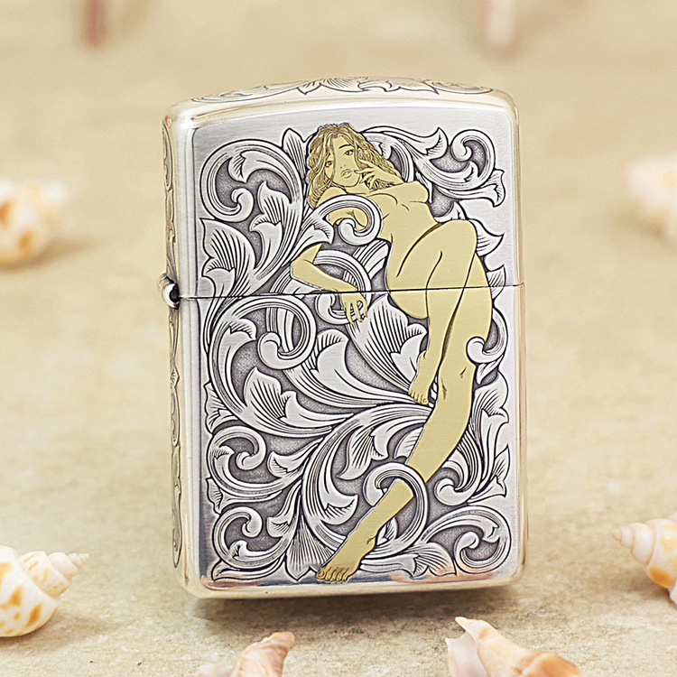 Lighter with ornate black-and-white scrollwork and a stylized nude woman illustration in gold tones.