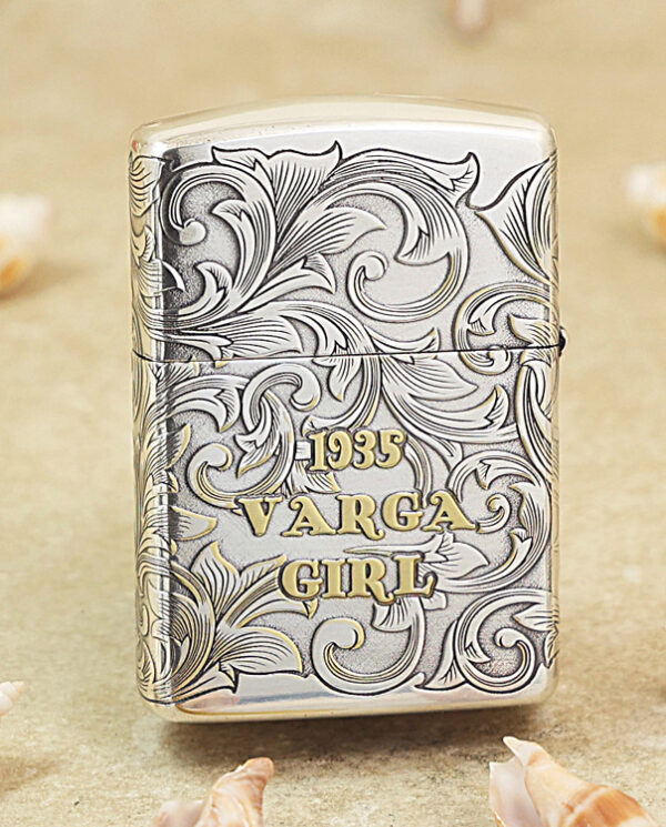 KZ287-01 Metal lighter with intricate scroll engraving and gold lettering reading '1935 VARGA GIRL' on a sandy background.