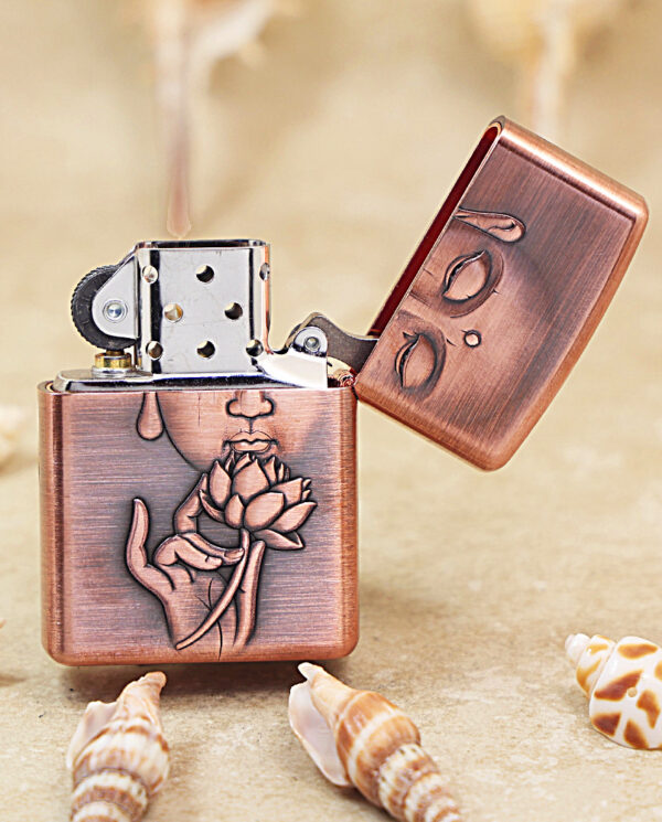KZ288-03 Copper-toned Zippo lighter with an open lid, featuring an engraved hand holding a lotus flower on the body.