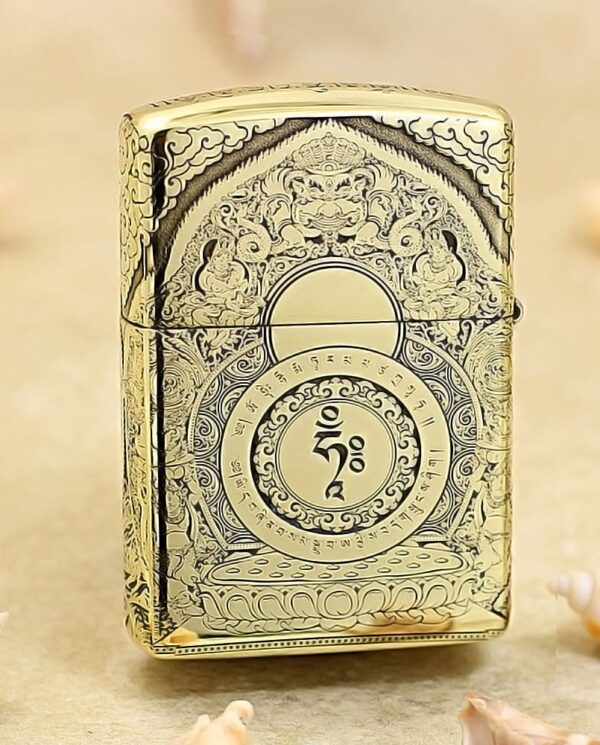 KZ304-01 Ornate gold lighter with intricate engravings and a central circular motif, standing on a beige surface.