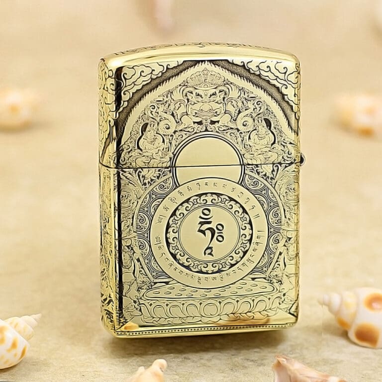 Ornate gold lighter with intricate engravings and a central circular motif, standing on a beige surface.