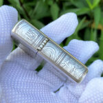 Hinge-side view showing Holy Bible title and ornamental engraving on the sterling silver Armor lighter