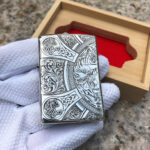 Four Horsemen engraved sterling silver Zippo lighter beside its wooden presentation box