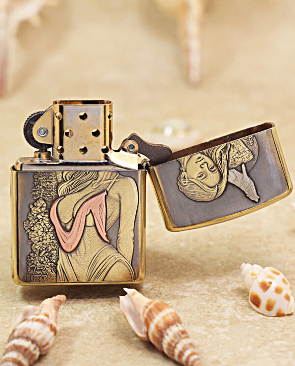 KZ452-03 Bronze Zippo lighter with vintage bathing‑suit artwork on its panels, open lid on a sandy beach with seashells.