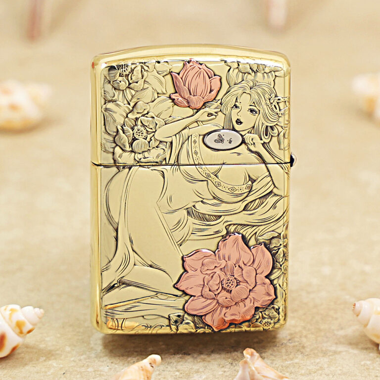 Gold decorative lighter featuring line-art of a reclining woman among pink flowers, on a metallic surface.
