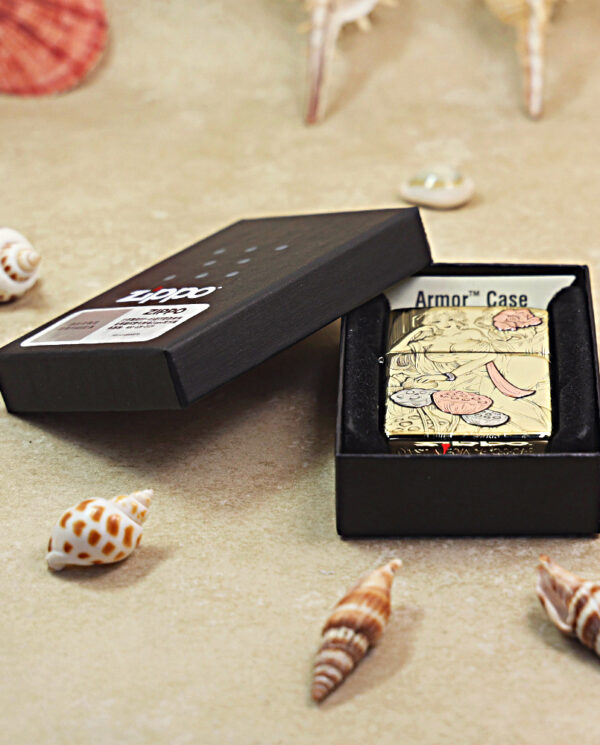 KZ456-06 Zippo lighter with artwork in an Armor Case inside a black display box on a shell-strewn beach background.