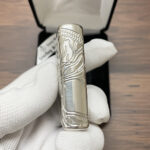 Wraparound tree engraving on the side of the sterling silver Zippo Armor lighter