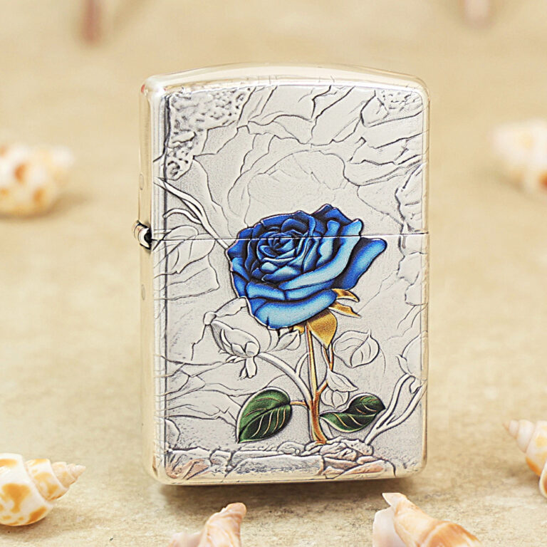 Metal lighter with a cracked silver surface and a blue rose design in the center