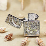 Open silver-tone H.R. Giger Alien Zippo Armor lighter front view