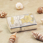 Metal Zippo lighter on sand with seashells, featuring Toy Story Woody design.