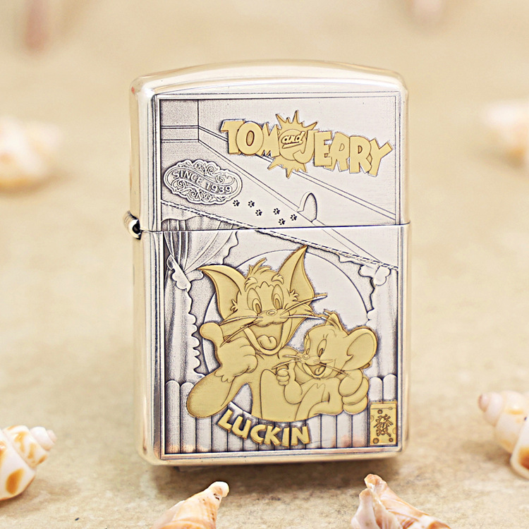 Metal Zippo lighter with a Tom and Jerry cartoon on the front, showing Tom and Jerry posing together with the 'Tom and Jerry' label at the top and 'LUCKIN' text at the bottom.