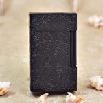 Karl Wieden KW-T0208D petrol lighter, front view showing black Constantine cross medallion and flowing scroll ornament