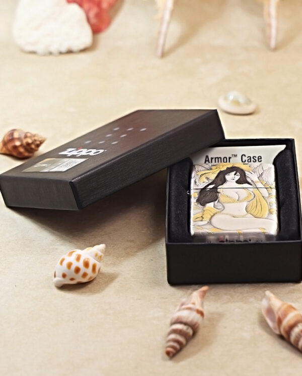 Open black box revealing an illustrated Armor Case with a woman on the cover, on a seashell-strewn surface.
