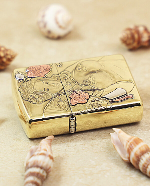 KZ506-04 Gold decorative case with an engraved woman and floral design, placed among seashells on sand.