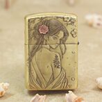 Gold Zippo lighter engraved with a woman in a flowing dress and flowers in her hair.