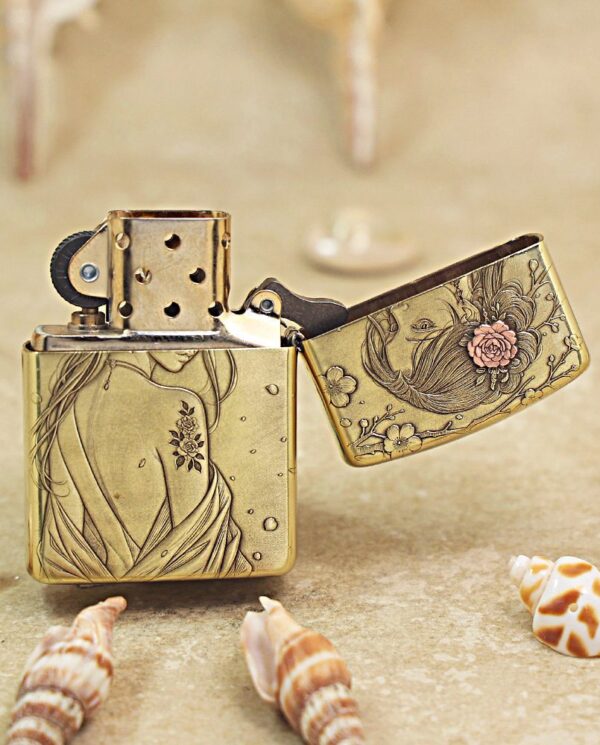 KZ509-03 Vintage brass lighter with floral engravings, open lid, resting on sandy surface among seashells for decorative effect