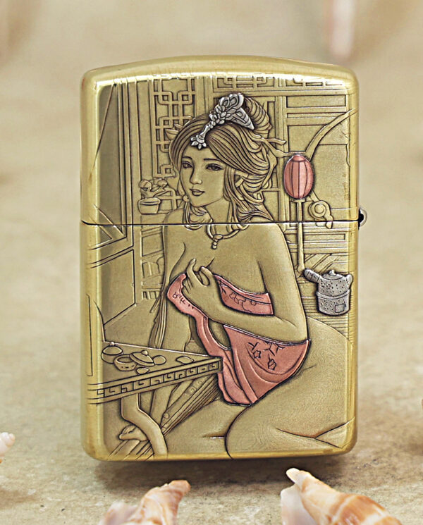 KZ510-01 Gold-toned lighter engraved with a seated woman in a pink dress at a vanity against a geometric background.