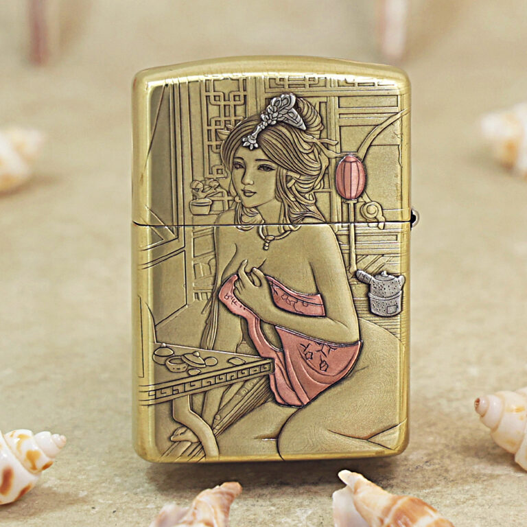 Gold-toned lighter engraved with a seated woman in a pink dress at a vanity against a geometric background.