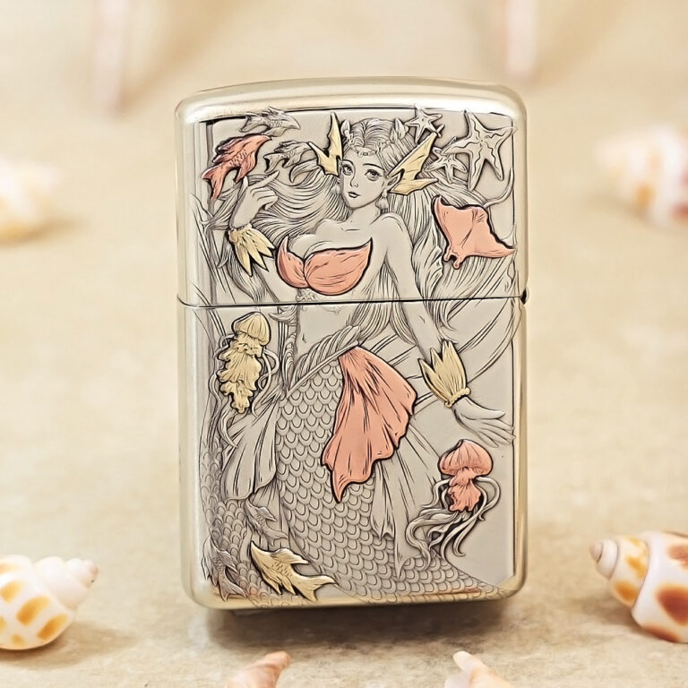 Metal lighter with an engraved mermaid design, pink-orange accents and sea-life details on a silver surface.