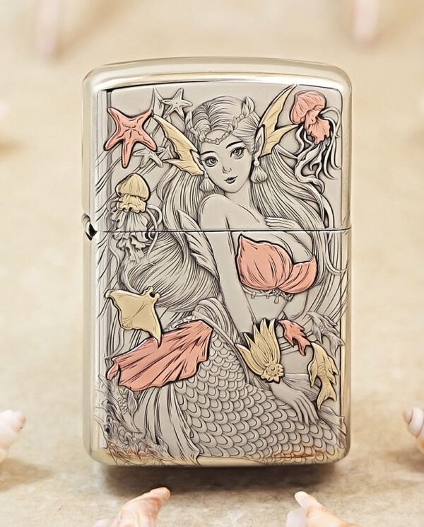 Metal lighter with a detailed mermaid illustration in pale pink and gold tones, other sea motifs around her.