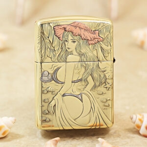 Gold Zippo lighter engraved with a beach scene: a woman with long hair and a pink hat among seashells on the shore.