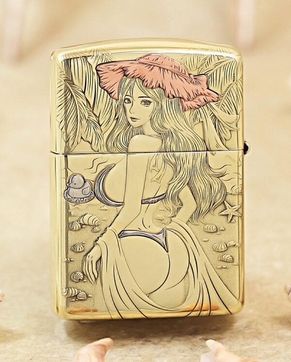 Gold Zippo lighter engraved with a beach scene: a woman with long hair and a pink hat among seashells on the shore.