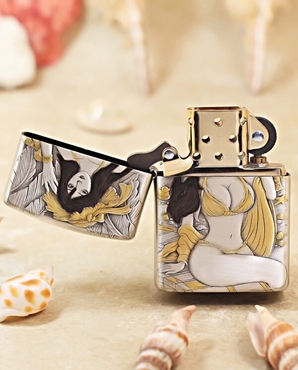 KZ370-02 Open decorative Zippo-style lighter with a detailed illustration of a woman in gold and gray tones, set on a sandy surface among seashells.