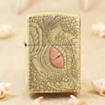 KZ371 high-polish brass Zippo Armor lighter with dragon-scale engraving and pink-red eye accent