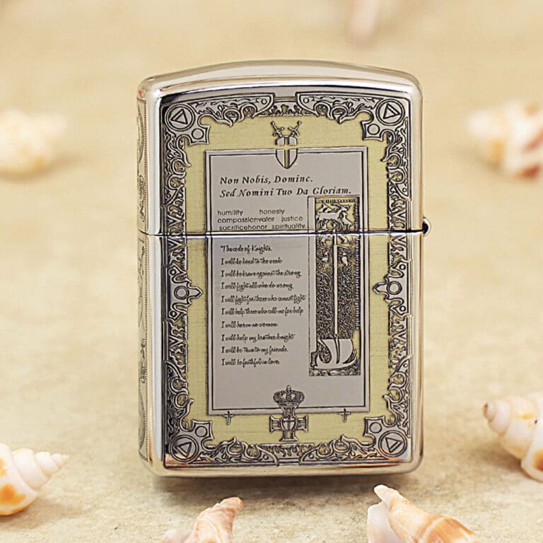 Ornate chrome Zippo-style lighter on a sandy beach with seashells nearby.