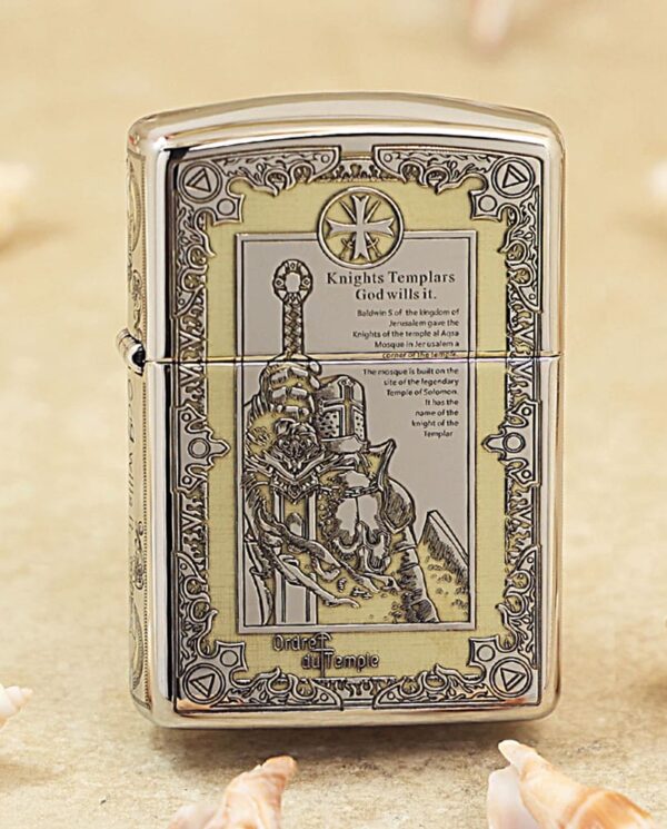 Metal lighter with an ornate Knights Templar engraving and decorative border on a beige surface