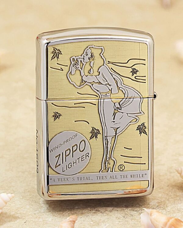 Shiny Zippo lighter with an engraved art of a woman in a dress, standing and leaning forward, on a sandy beach background.