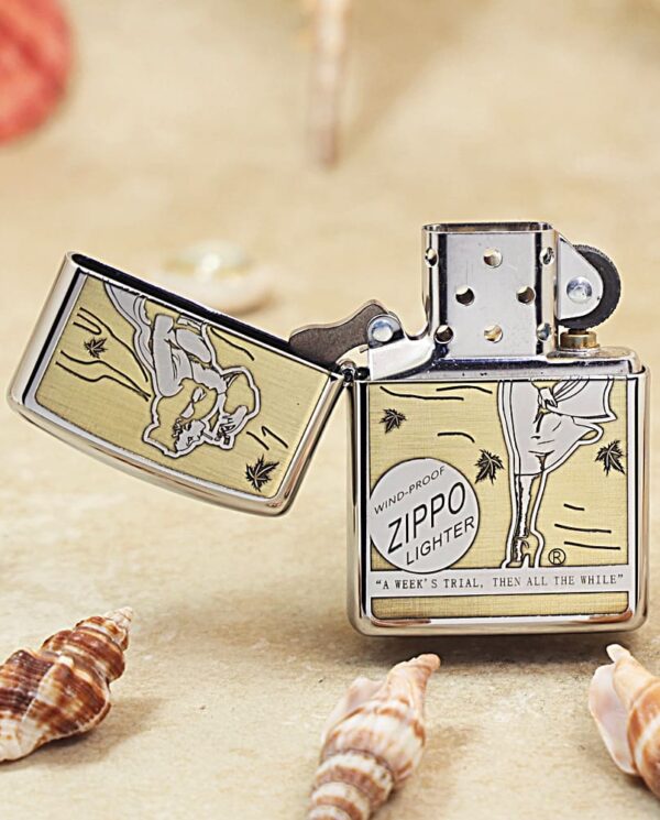 Wind-proof Zippo lighter with retro beige comic artwork, open lid, on sandy beach with seashells and text reading Zippo lighter.