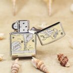 Metal Zippo lighter with vintage engraving, open lid, surrounded by seashells on a sandy surface (informational product photo).