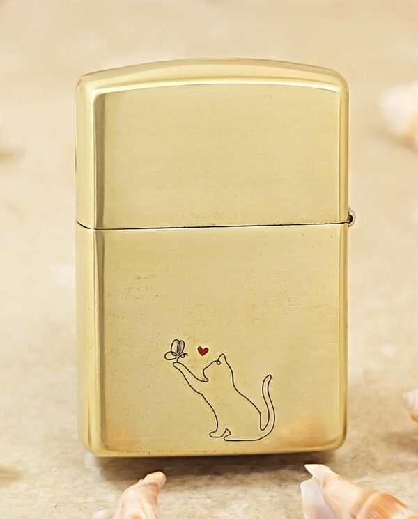KZ135-01 Gold metal lighter with a minimalist line drawing of a cat reaching for a butterfly, a small red heart above the butterfly.
