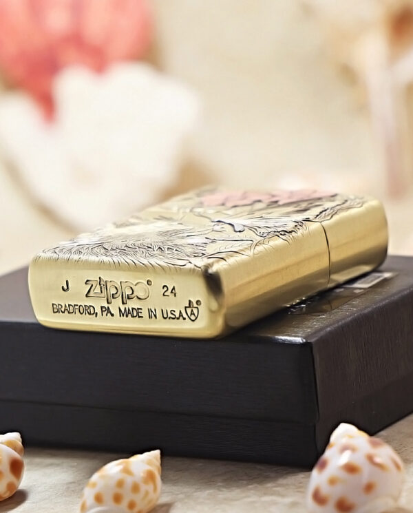 KZ135-05 Brass Zippo lighter with engraved pattern resting on a black box, showing 'Zippo' and 'Bradford, PA Made in USA' text