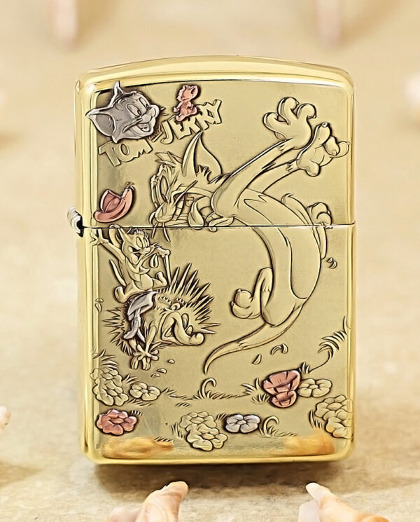 KZ117 Gold-tone Zippo-style lighter with an engraved Tom and Jerry scene in a garden, showing Tom, Jerry, and flowers