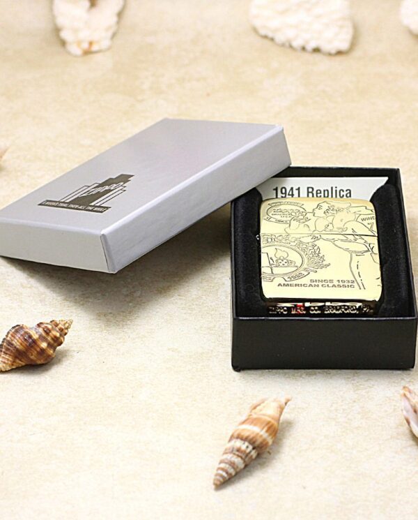 KZ161-06 Zippo lighter with a vintage 1941 Replica design in an open black presentation box on a sandy surface with several seashells nearby.